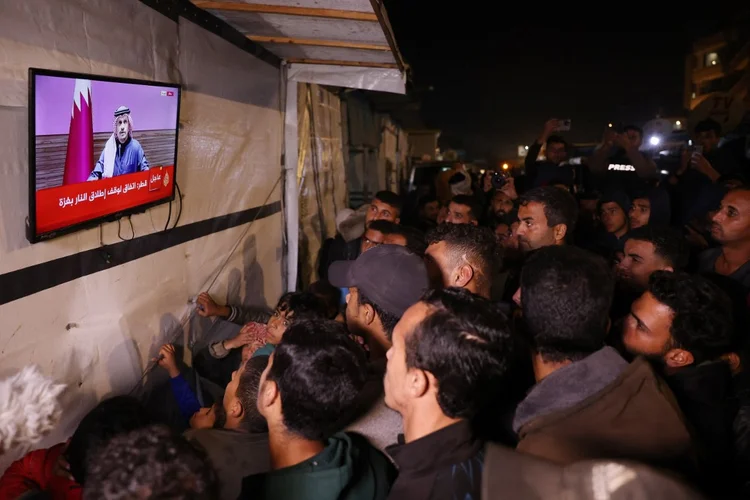 Palestinos assistem a anúncio de cessar-fogo em TV em Khan Yunis, na Faixa de Gaza (Bashar Taleb/AFP)