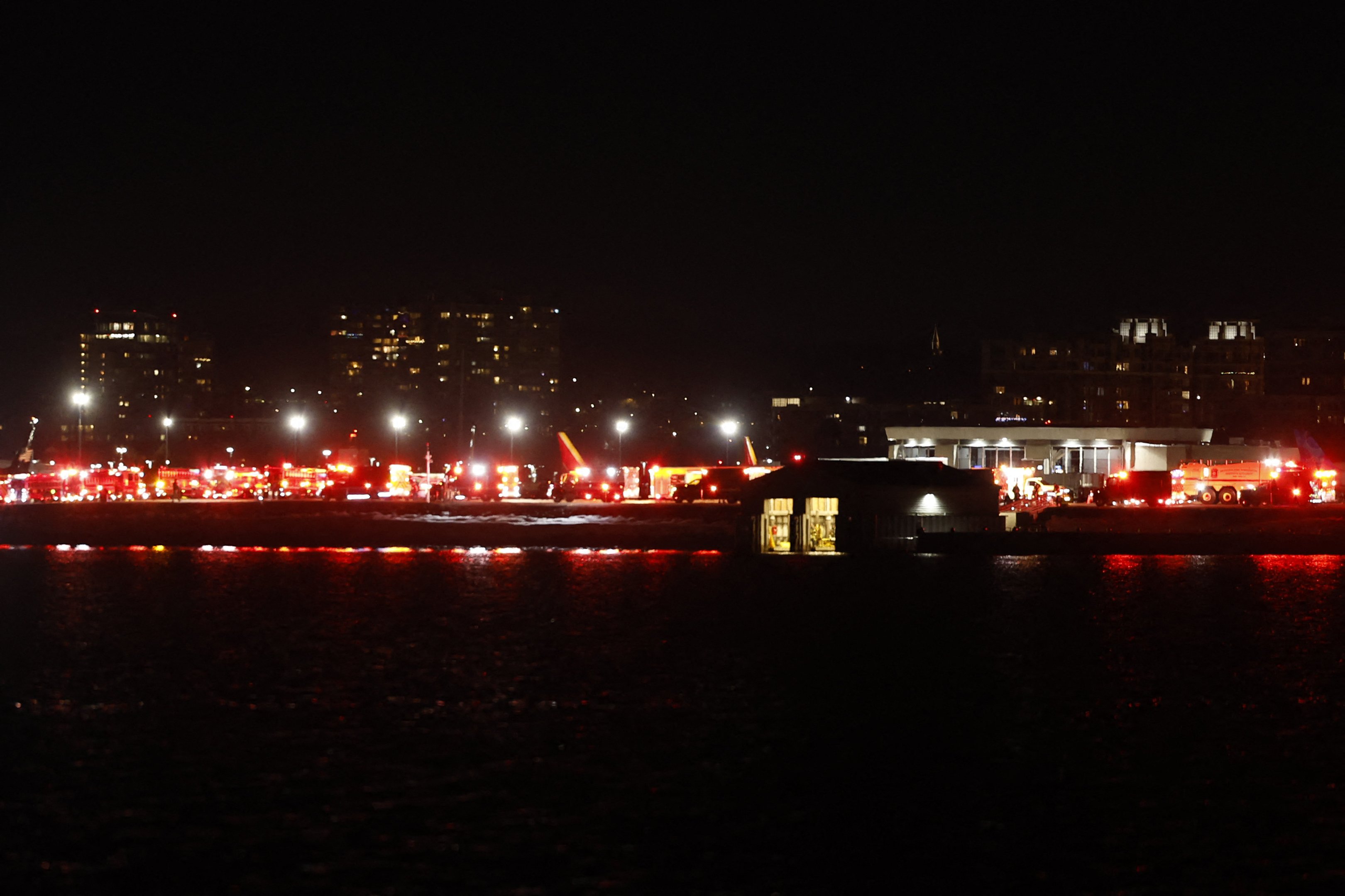 Luzes de veículos de emergência são vistas no Aeroporto Nacional Reagan em Washington, DC, após um acidente aéreo perto do Rio Potomac em 29 de janeiro de 2025. Várias equipes estavam respondendo na quarta-feira após um "aparente acidente aéreo" no Rio Potomac em Washington, com o Aeroporto Nacional Reagan relatando pistas fechadas devido a uma emergência em andamento