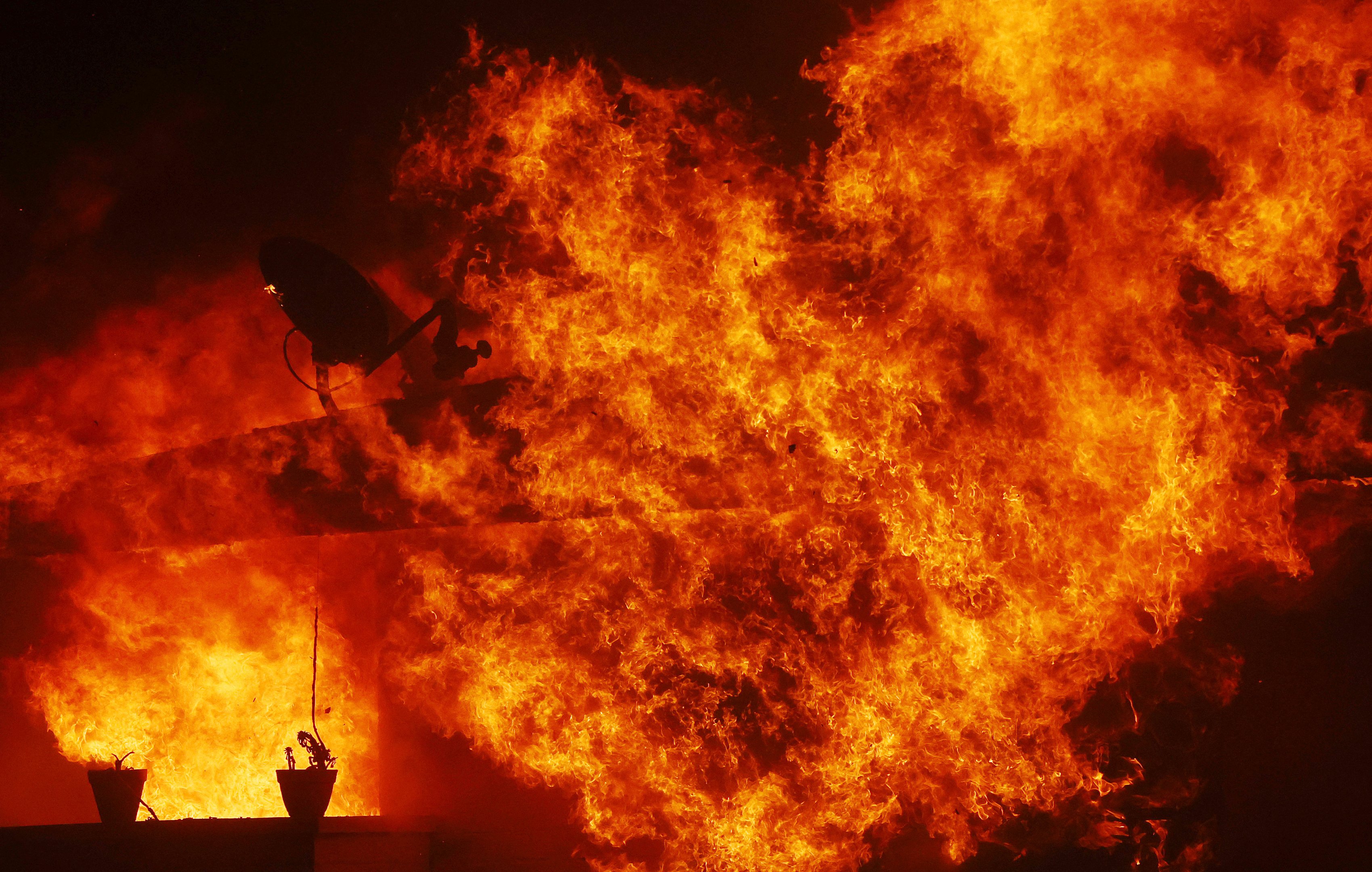 PASADENA, CALIFORNIA - JANUARY 07: A home burns during the Eaton Fire while a powerful windstorm impacts the region on January 7, 2025 in Pasadena, California. Fueled by intense Santa Ana Winds, the Palisades Fire has grown to over 2,900 acres and 30,000 people have been ordered to evacuate while a second fire has emerged near Eaton Canyon.   Mario Tama/Getty Images/AFP (Photo by MARIO TAMA / GETTY IMAGES NORTH AMERICA / Getty Images via AFP)