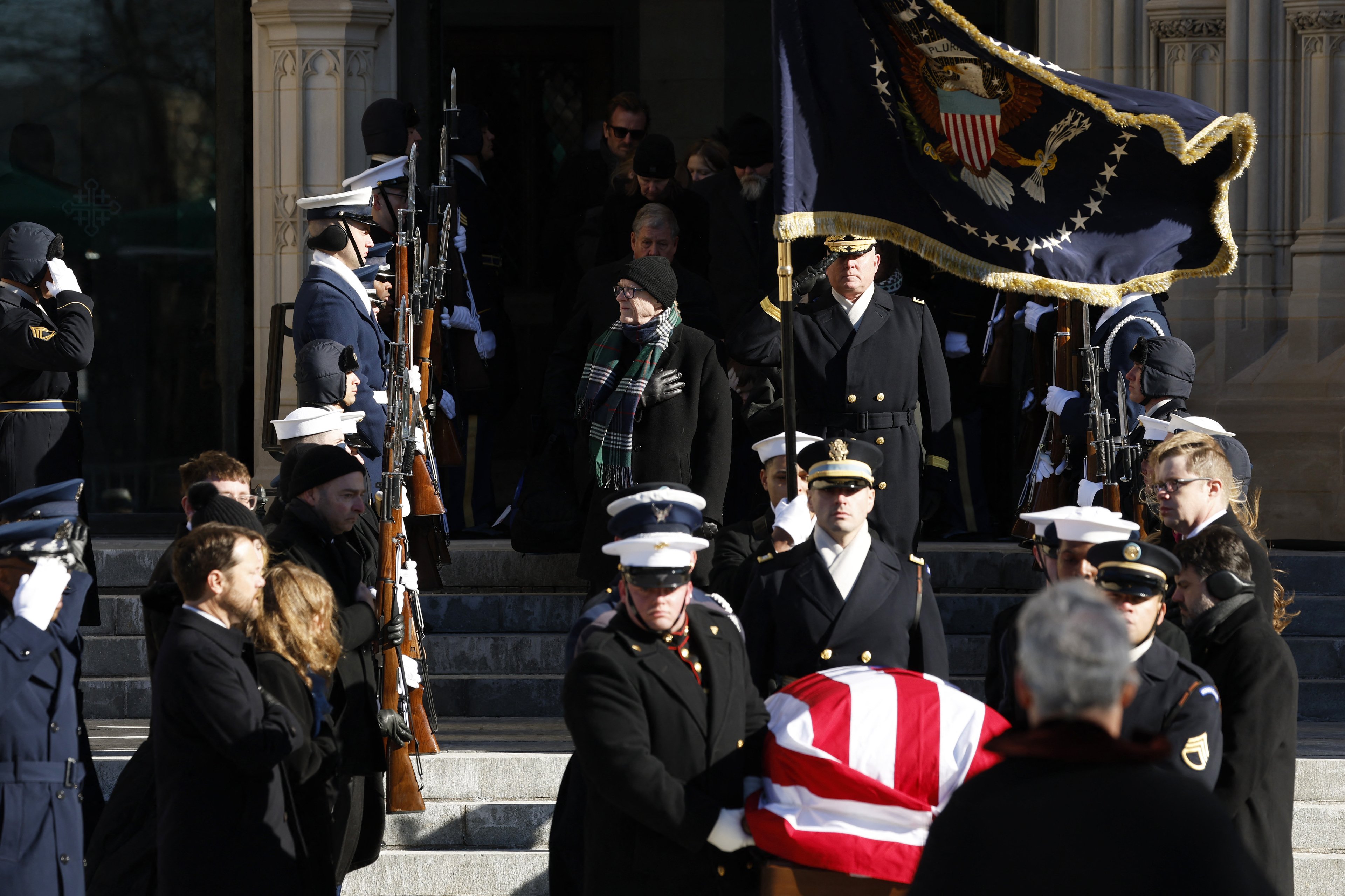 WASHINGTON, DC - JANUARY 09: Jack Carter (C), son of former U.S. President Jimmy Carter, looks on as U.S. Military Body Bearers carry the flag-draped casket bearing the remains of former President Carter from the Washington National Cathedral following his state funeral on January 09, 2025 in Washington, DC. President Joe Biden declared today a national day of mourning for Carter, the 39th President of the United States, who died at the age of 100 on December 29, 2024 at his home in Plains, Georgia.   Anna Moneymaker/Getty Images/AFP (Photo by Anna Moneymaker / GETTY IMAGES NORTH AMERICA / Getty Images via AFP)