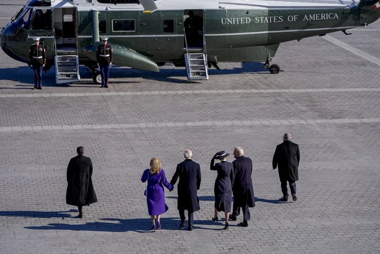 Joe Biden e a mulher, Jill, caminham para helicóptero após posse de Donald Trump, na segunda, 20 (Jack Gruber/AFP)