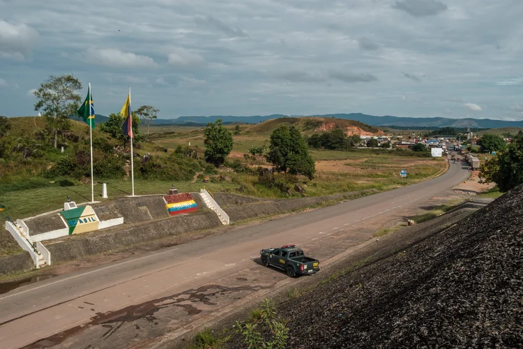 Um carro da Polícia da Força Nacional (polícia especializada do Brasil) permanece na fronteira entre a cidade venezuelana de Santa Elena de Uairen e Pacaraima, no norte do Brasil, ao lado de bandeiras de ambos os países (Getty Images/Getty Images)