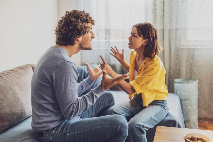 Man and woman are sitting at sofa and arguing. Relationship problems. (Photodjo/Getty Images)