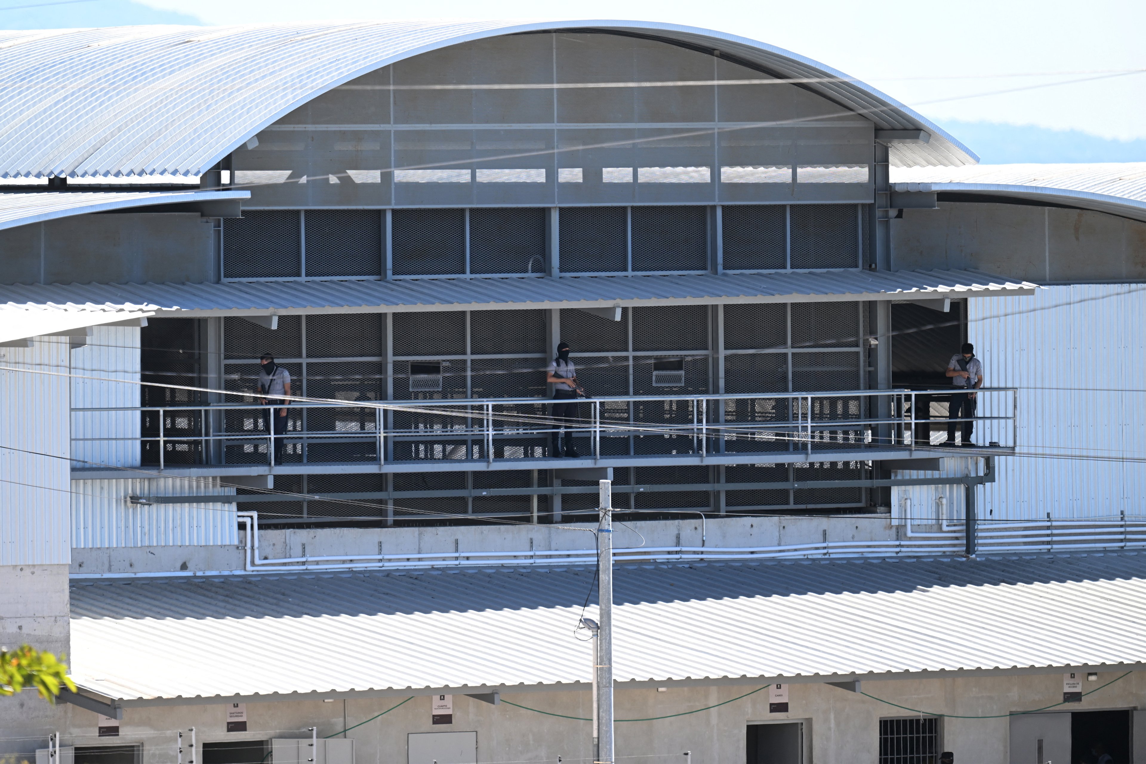 Agentes penitenciários montam guarda em um pavilhão dentro da megaprisão do Centro de Confinamento Antiterrorismo (CECOT), onde centenas de membros das gangues MS-13 e 18 Street estão detidos, em Tecoluca, El Salvador, em 27 de janeiro de 2025. O CECOT, a maior prisão da América Latina e emblema da guerra contra as gangues do governo do presidente Nayib Bukele, comemora dois anos desde sua inauguração em 1º de fevereiro. (Foto de Marvin RECINOS / AFP)