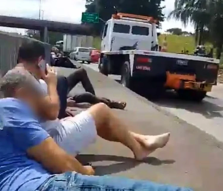 Motoristas se abrigam na mureta da Avenida Brasil durante o tiroteio  (Reprodução de vídeo)