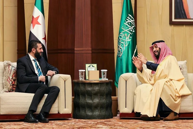 O presidente interino sírio Ahmed al Sharaa ao lado do príncipe herdeiro saudita Mohamed bin Salman em Riad (AFP/AFP)