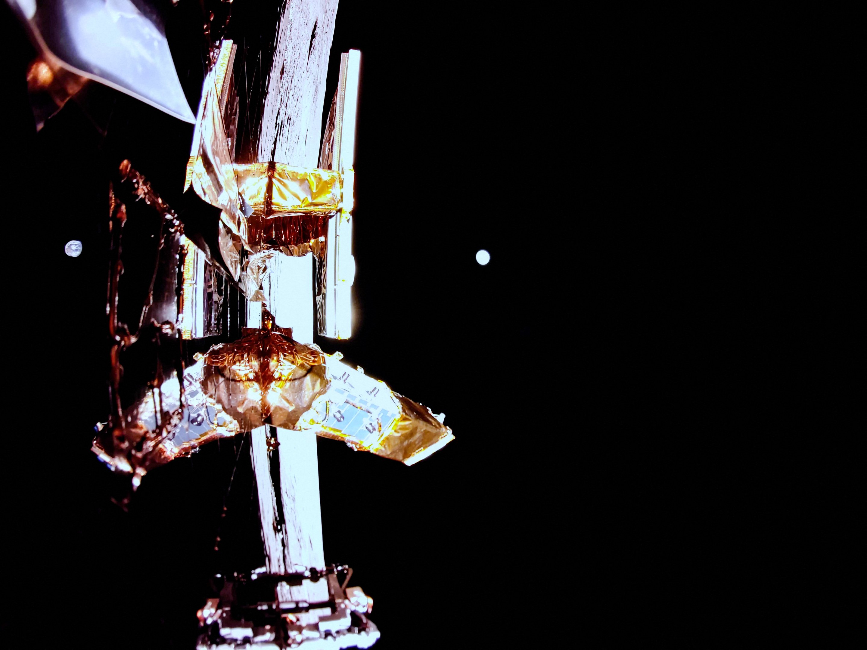 This handout photograph taken and released by Firefly Aerospace on March 2, 2025, shows the Moon's surface, Earth on the horizon, and Blue Ghost's top deck with its solar panel, X-band antenna (L), and LEXI payload (R) in the view. A US company successfully landed its spacecraft on the Moon on March 2, 2025, making it only the second private lander to achieve this milestone, a live webcast from mission control showed. Firefly Aerospace's Blue Ghost Mission 1 touched down at 3:34 am US Eastern Time (0834 GMT) near Mons Latreille, a volcanic formation in Mare Crisium on the Moon's northeastern near side. (Photo by Handout / Firefly Aerospace / AFP) / RESTRICTED TO EDITORIAL USE - MANDATORY CREDIT "AFP PHOTO / HANDOUT / Firefly Aerospace" - NO MARKETING NO ADVERTISING CAMPAIGNS - DISTRIBUTED AS A SERVICE TO CLIENTS