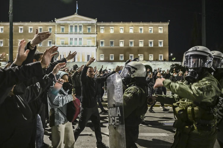 Protestors (L) react next to riot police (R) in a demonstration asking for justice for the victims of the country's worst rail tragedy in 2023, in Athens on March 5, 2025. Greek opposition parties on March 5, 2025, submitted a motion to trigger a no-confidence vote against the government over its handling of the country's worst rail tragedy in 2023, the head of the socialist party said. (Photo by Aris MESSINIS / AFP) (Aris MESSINIS/AFP)