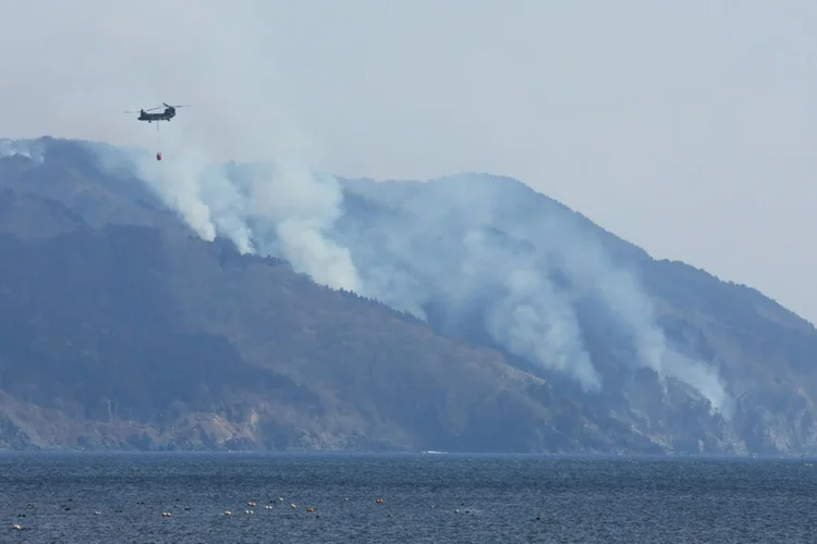 Incêndio: helicóptero sobrevoa um incêndio florestal na encosta de uma montanha perto da cidade de Ofunato, na prefeitura de Iwate (AFP/AFP Photo)