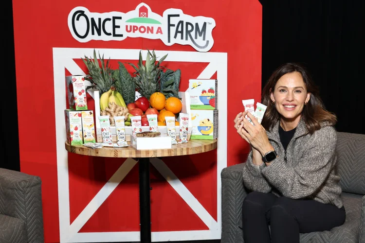 A atriz Jennifer Garmer posa ao lado de produtos da marca Once Upon a Farm, de papinhas orgânicas (Getty Images)