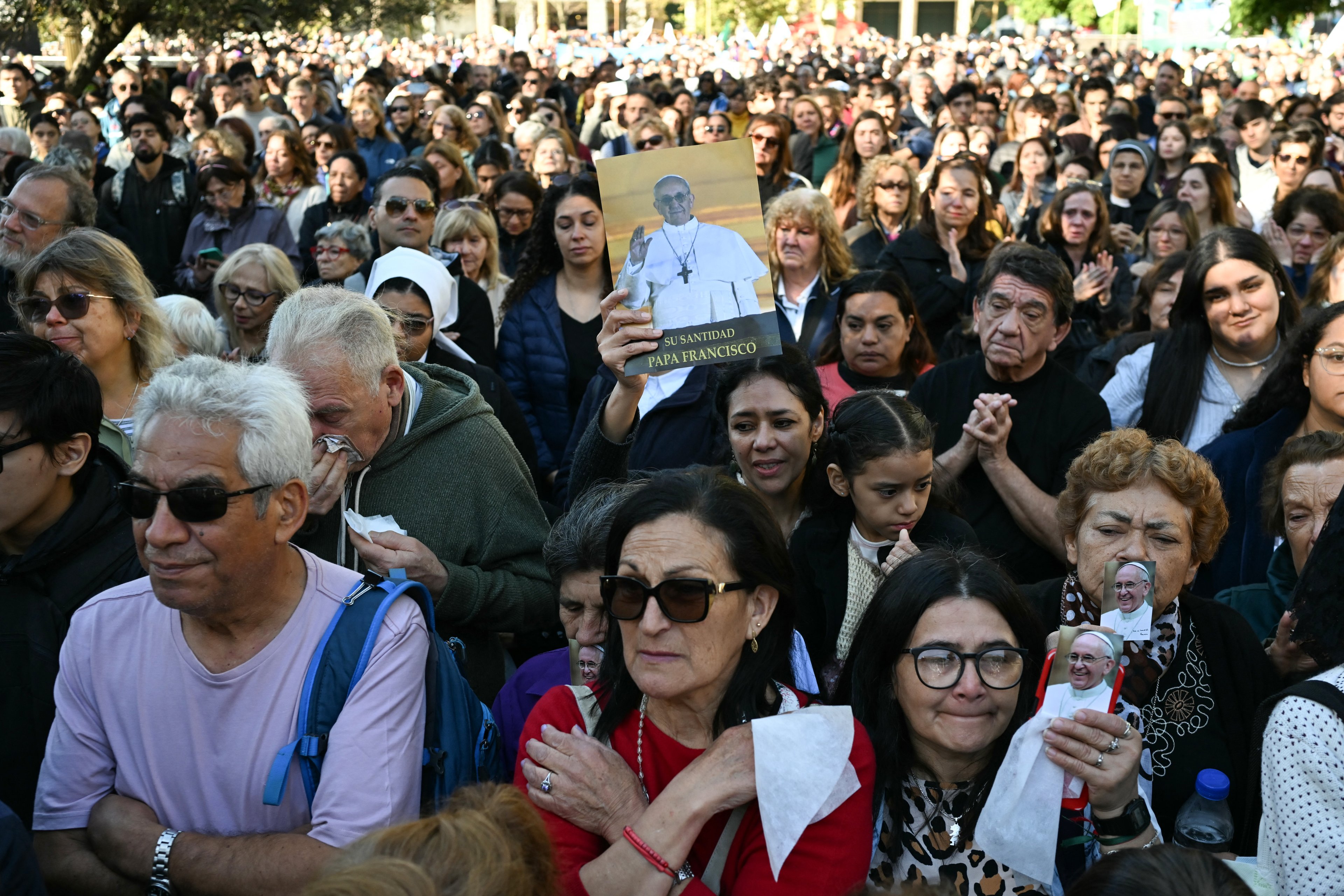 Faithful attend a mass to bid farewell to Pope Francis in front of the Buenos Aires Cathedral on April 26, 2025. With songs, candles, flags, and prayers, Buenos Aires mourners marked the burial of pontiff and native son Pope Francis on Saturday. As the 88-year-old was being laid to rest an ocean away in Rome, thousands gathered by Buenos Aires' cathedral for dawn vigils and a mass of remembrance. (Photo by Luis ROBAYO / AFP)