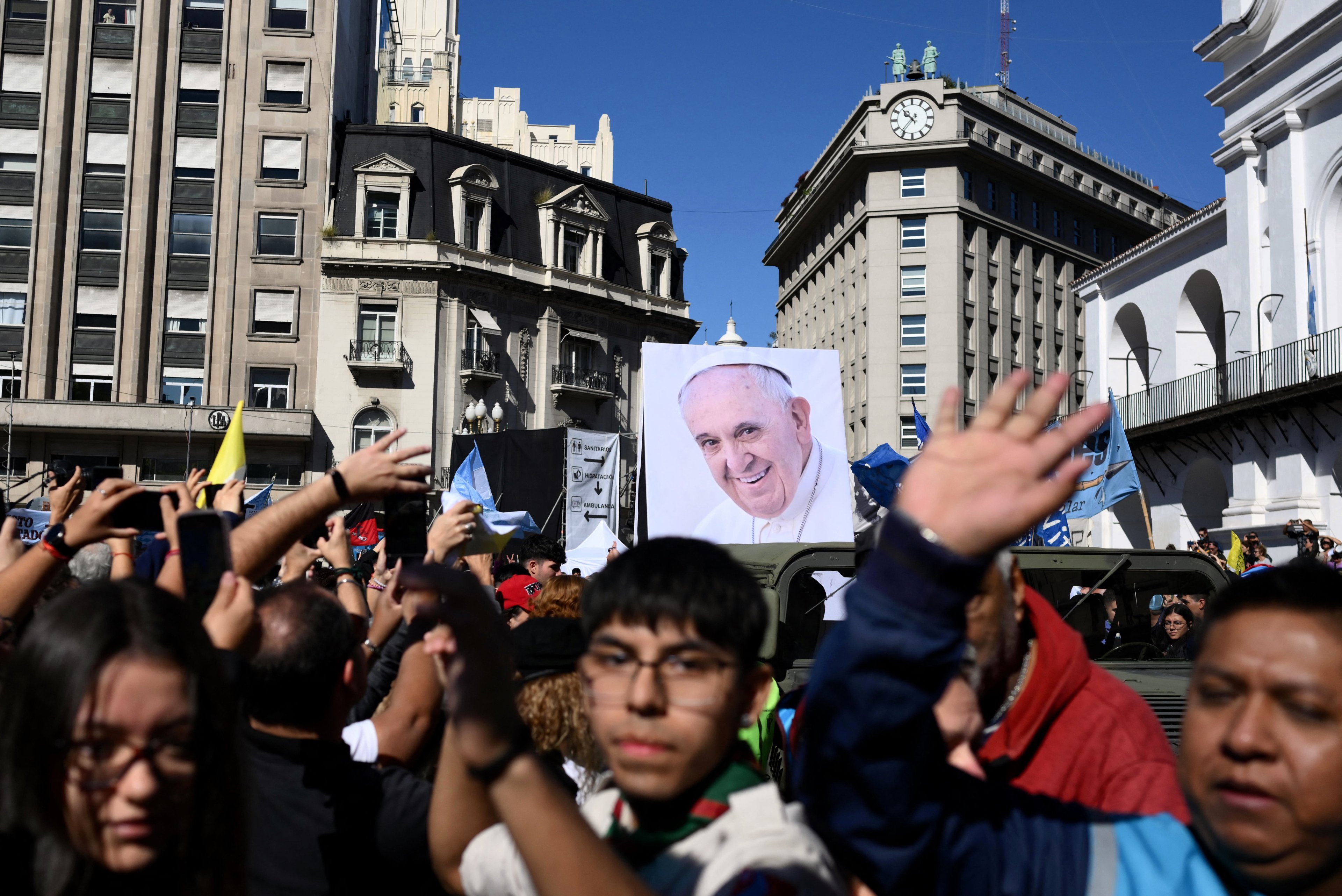 A military vehicle carries an image of Pope Francis during a pilgrimage through Buenos Aires on April 26, 2025, after a mass to bid him farewell. With songs, candles, flags, and prayers, Buenos Aires mourners marked the burial of pontiff and native son Pope Francis on Saturday. As the 88-year-old was being laid to rest an ocean away in Rome, thousands gathered by Buenos Aires' cathedral for dawn vigils and a mass of remembrance. (Photo by Luis ROBAYO / AFP)