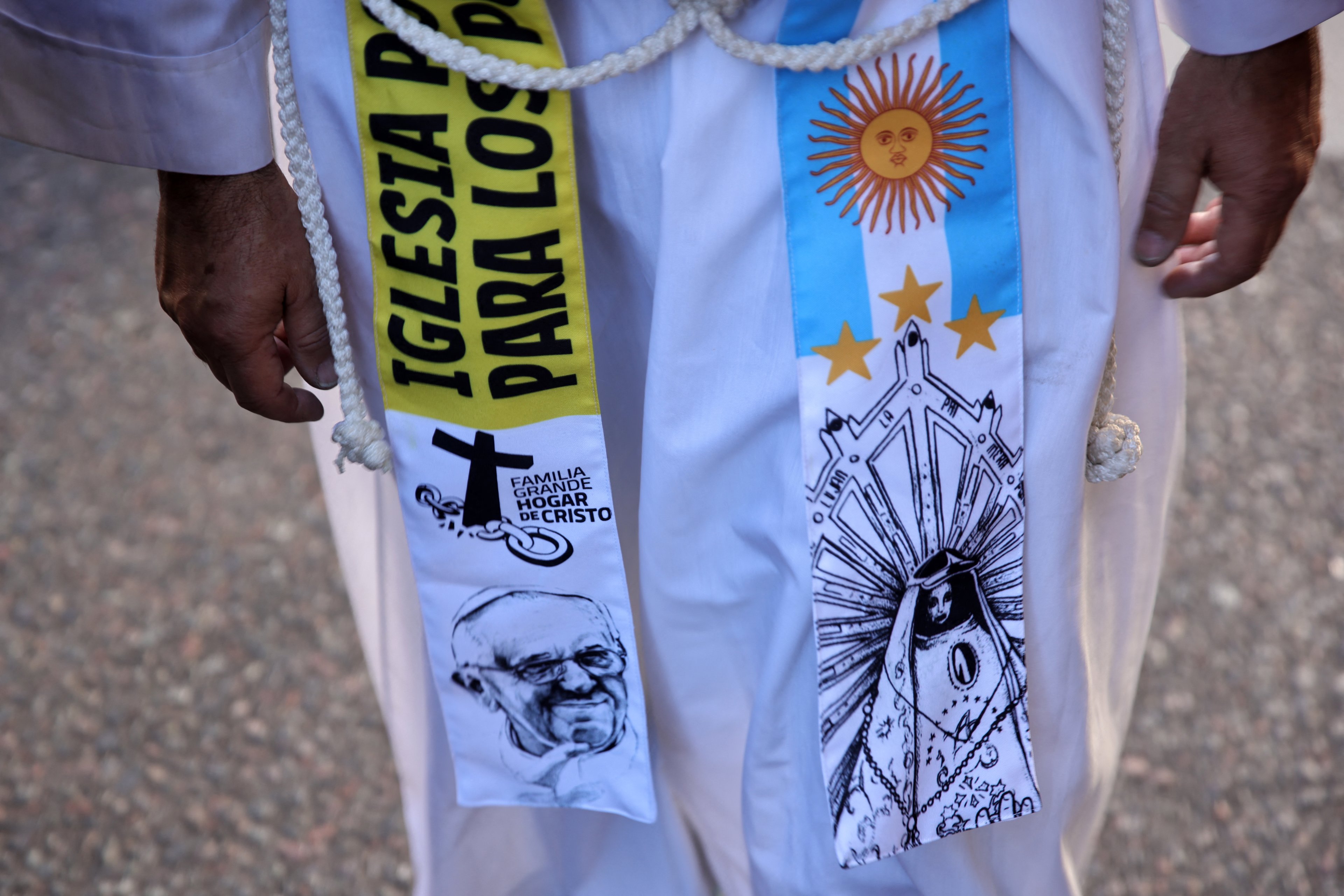 A priest participates in a pilgrimage through emblematic places for Pope Francis in Buenos Aires on April 26, 2025, after a mass to bid him farewell. With songs, candles, flags, and prayers, Buenos Aires mourners marked the burial of pontiff and native son Pope Francis on Saturday. As the 88-year-old was being laid to rest an ocean away in Rome, thousands gathered by Buenos Aires' cathedral for dawn vigils and a mass of remembrance. (Photo by Emiliano Lasalvia / AFP)
