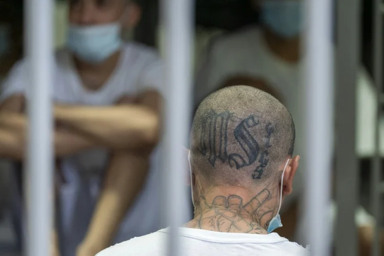 Preso com tatuagens da gangue salvadorenha MS-13 dentro da cela com outros detentos no Centro de Confinamento do Terrorismo (CECOT), em Tecoluca, El Salvador (AFP)