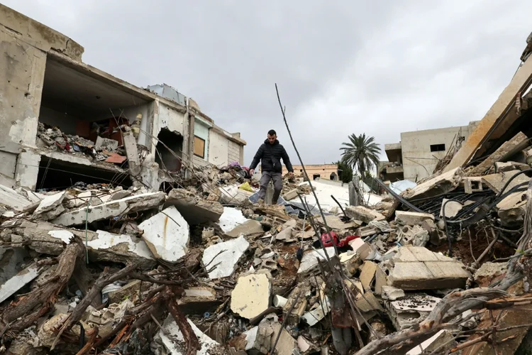 Um morador de Zibqin caminha sobre os escombros de um prédio destruído pela guerra entre Israel e o grupo islamista xiita Hezbollah (AFP/AFP Photo)