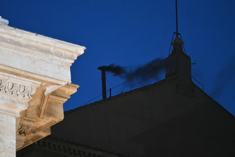 Fumaça preta em chaminé do Vaticano, que indica que eleição para novo papa não teve vencedor, na noite de quarta, 7 de maio (Alberto Pizzoli/AFP)