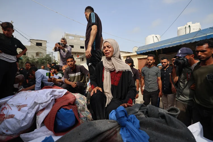 Mulher chora após ataque de Israel que matou membros de sua família neste domingo em Deir el-Balah, centro de Gaza (Eyad BABA / AFP)