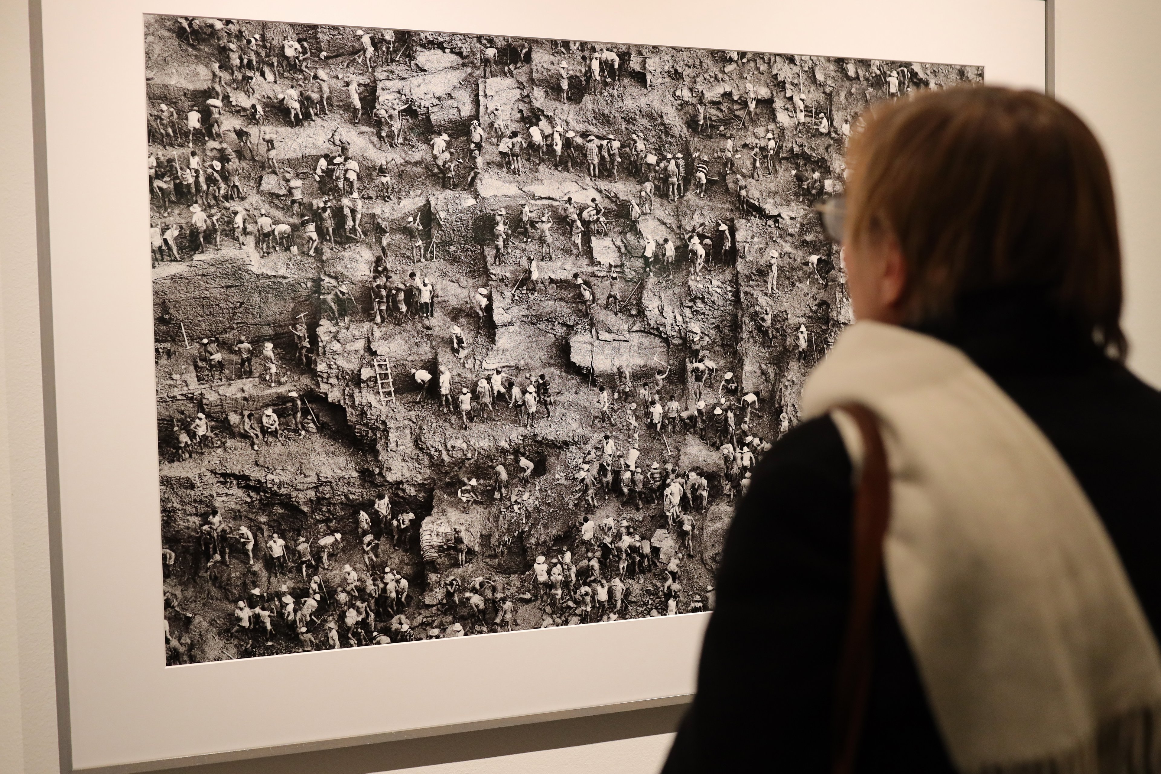 COLOGNE, GERMANY - FEBRUARY 06:  A visitor looks at a photograph at the exhibition opening "Gold" by Brazilian documentary photographer Sebastiao Salgado at Galerie Bene Taschen on February 06, 2020 in Cologne, Germany. The exhibition runs from February 7 to May 9. (Photo by Andreas Rentz/Getty Images)