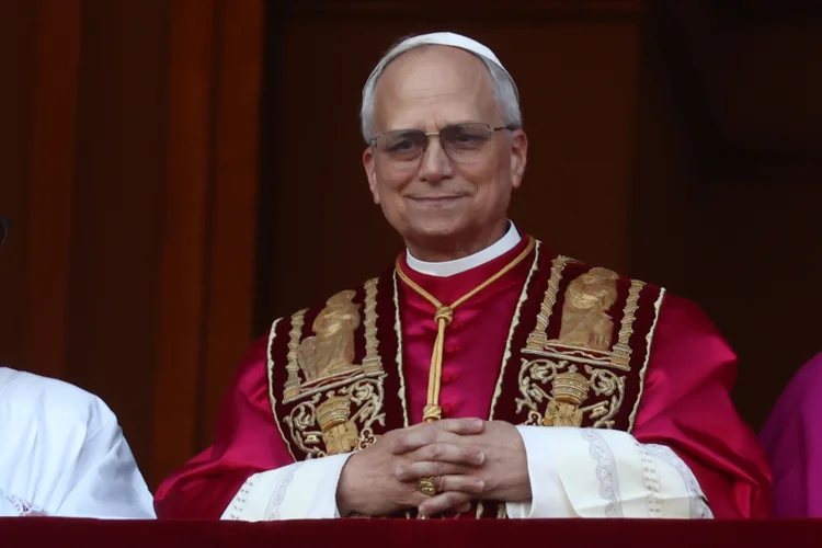 O recém-eleito Papa Robert Francis Prevost chega à varanda central principal da Basílica de São Pedro pela primeira vez, após os cardeais encerrarem o conclave, no Vaticano, em 8 de maio de 2025 (Jakub Porzycki/NurPhoto/Getty Images)