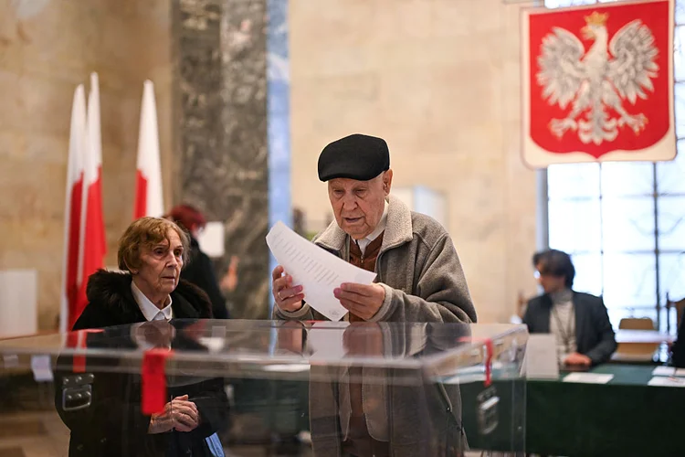 Um casal de idosos deposita seus votos durante o primeiro turno das eleições presidenciais em 18 de maio de 2025, em Varsóvia, Polônia (Omar Marques/Getty Images)