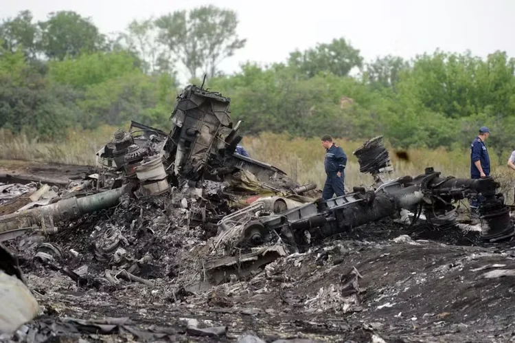 Equipes de resgate em 18 de julho de 2014 no local da queda de um avião da Malaysia Airlines, que transportava 298 pessoas de Amsterdã para Kuala Lumpur (DOMINIQUE FAGET / AFP)