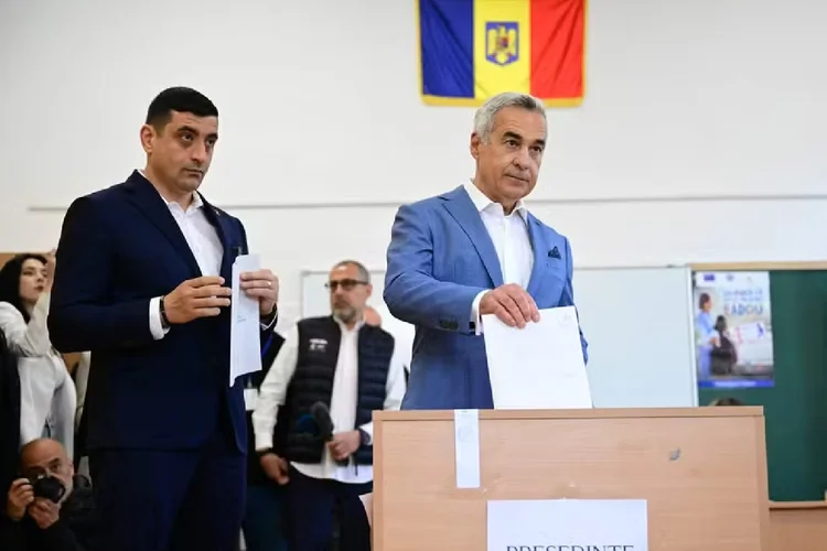 Eleições na Romênia: Líder do partido nacionalista AUR, George Simion, aguarda ex-candidato de extrema impedido de concorrer, Calin Georgescu, depositar seu voto durante o primeiro turno da eleição presidencial  (Daniel Mihailescu/AFP)