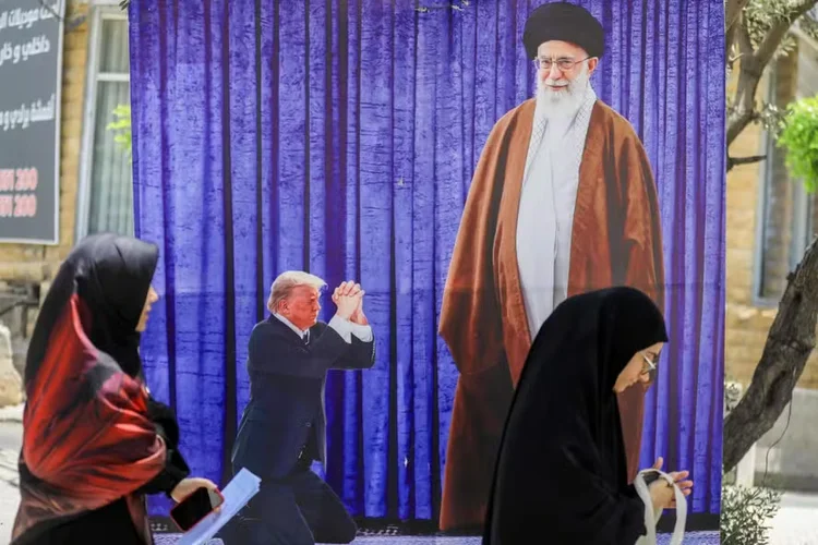 Pôster retratando o presidente dos EUA, Donald Trump, ajoelhando-se perante o líder supremo do Irça, o aiatolá Ali Khamenei, é visto no sul de Beirute, no Líbano ( AFP)