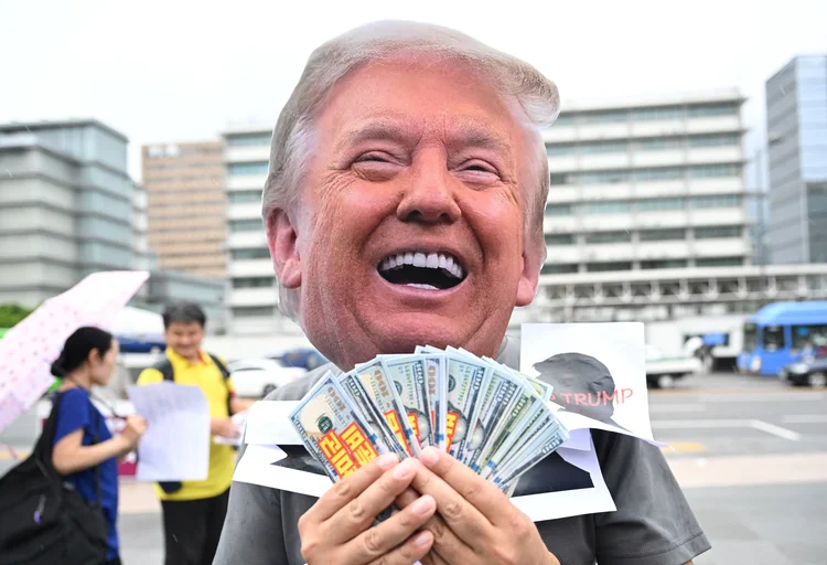 A member of civic groups wearing a mask of US President Donald Trump performs during a protest against Trump's tariff policy near the US embassy in Seoul on July 15, 2025. (Photo by Jung Yeon-je / AFP)