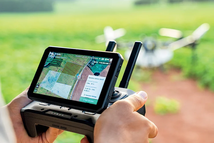 Técnico opera drone em plantação: dispositivo fornece dados de performance em tempo real (New Holland/Divulgação)