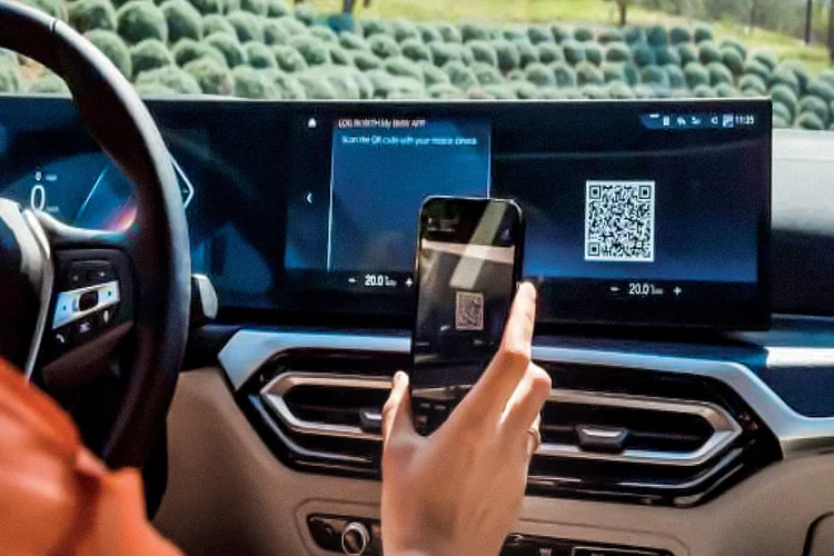 Motorista lê QR Code no painel do carro: esse é um dos métodos para ativar o e-SIM dos veículos conectados (Divulgação/Divulgação)