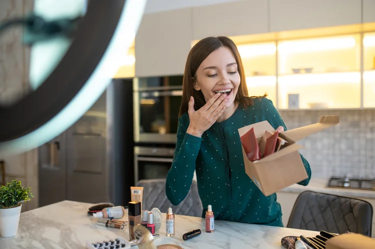 Sale. Young woman in green dress conducting online cosmetic sale (Freepik)