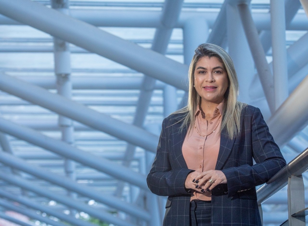 Imagem de uma mulher branca loira com terno azul