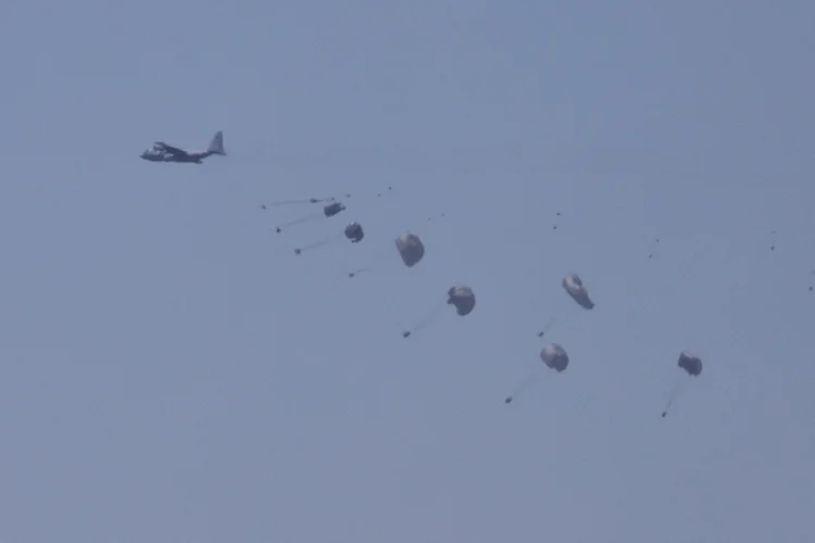Ajuda humanitária lançada do ar por um avião militar sobre o norte da Faixa de Gaza, vista do lado israelense da fronteira com Gaza, no sul de Israel, neste domingo, 3 (Abir Sultan/EFE)
