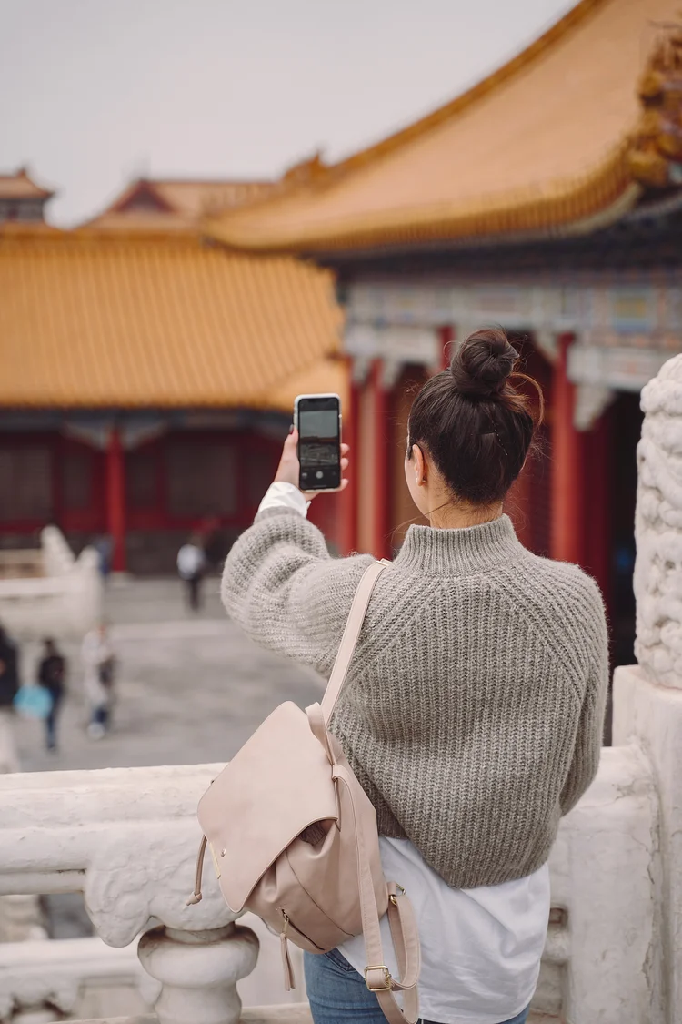 stylish girl visiting the forbidden city in Beijing China during autumn