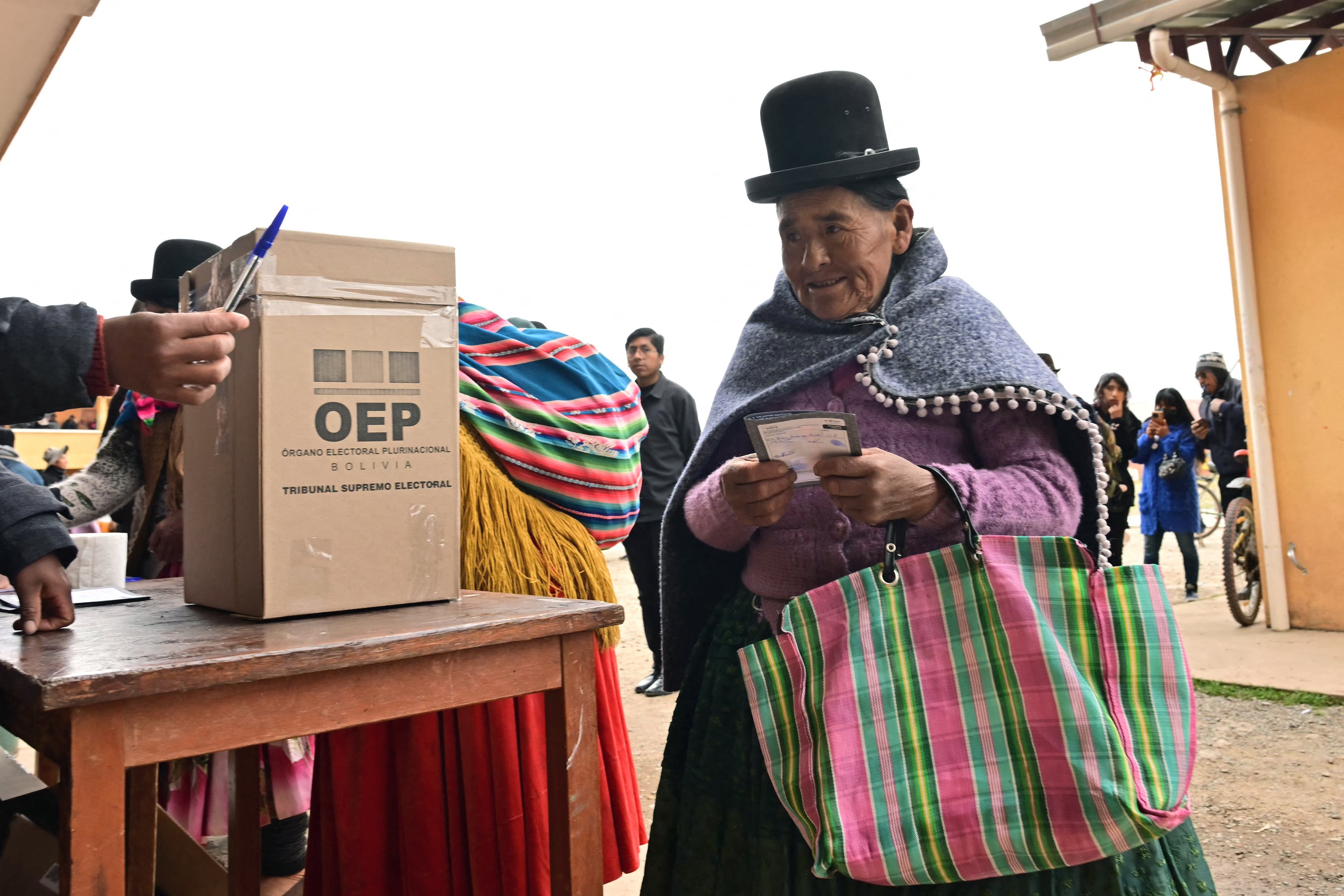 An Aymara woman prepares to cast her vote during the presidential runoff election, in Laja, some 30km west of La Paz, on October 19, 2025. Bolivians head to the polls to choose between right-wing candidates Jorge 'Tuto' Quiroga and Senator Rodrigo Paz, both promising change as the country of some 12 million people sees the end of two decades of socialist rule. (Photo by MARTIN BERNETTI / AFP)
