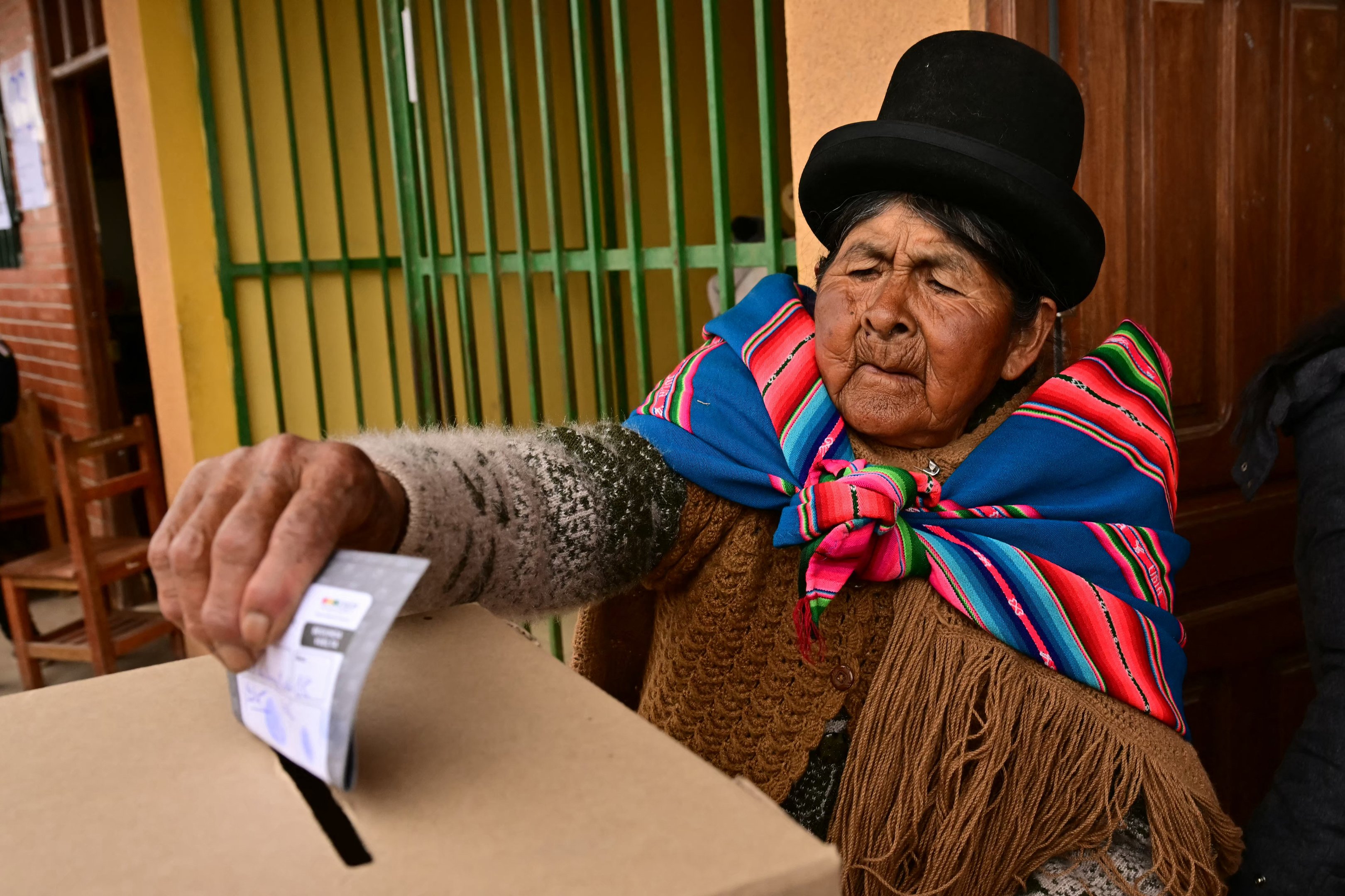 An Aymara woman casts her vote during the presidential runoff election, in Laja, some 30km west of La Paz, on October 19, 2025. Bolivians head to the polls to choose between right-wing candidates Jorge 'Tuto' Quiroga and Senator Rodrigo Paz, both promising change as the country of some 12 million people sees the end of two decades of socialist rule. (Photo by MARTIN BERNETTI / AFP)