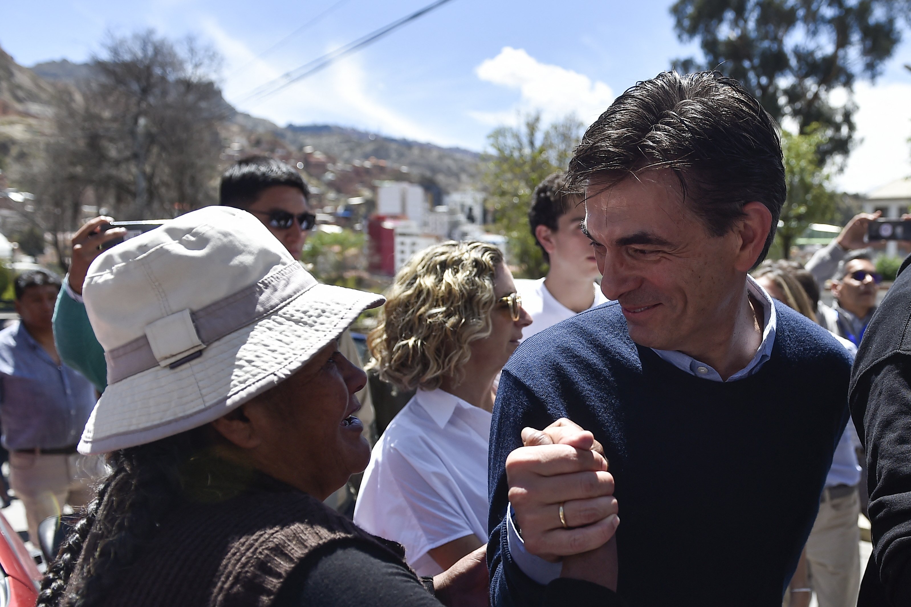 Bolivia's presidential candidate for the Christian Democratic Party (PDC), Rodrigo Paz, greets a supporter upon arriving at a polling station as he accompanies his daughter Catalina (out of frame) to vote during the presidential runoff election in La Paz on October 19, 2025. Bolivians head to the polls to choose between right-wing candidates Jorge 'Tuto' Quiroga and Senator Rodrigo Paz, both promising change as the country of some 12 million people sees the end of two decades of socialist rule. (Photo by Jorge BERNAL / AFP)