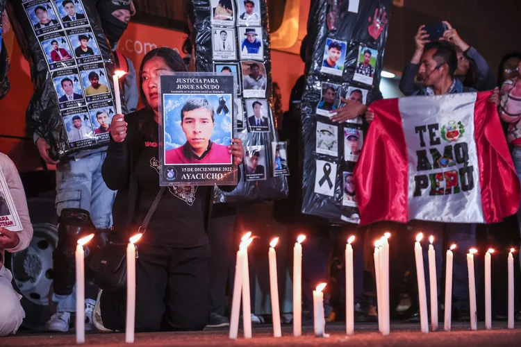 Protesto no Peru: manifestantes exibem cartazes com fotos de vítimas da violência, em Lima, em 25 de outubro (EFE)