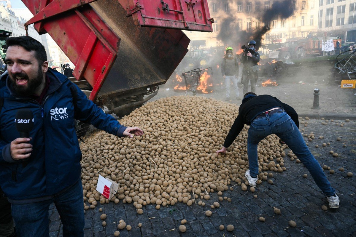 Pilha de batatas: Manifestantes pegam batatas perto do Parlamento Europeu durante um protesto de agricultores contra as reformas da Política Agrícola Comum (PAC) e acordos comerciais como o Mercosul