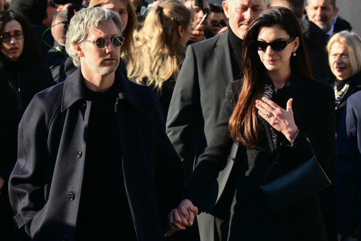 O ator americano Adam Shulman e a atriz americana Anne Hathaway (à direita) chegam à cerimônia fúnebre do estilista italiano Valentino Gavarani, na Basílica de Santa Maria degli Angeli e dei Martiri, em Roma, em 23 de janeiro de 2026.