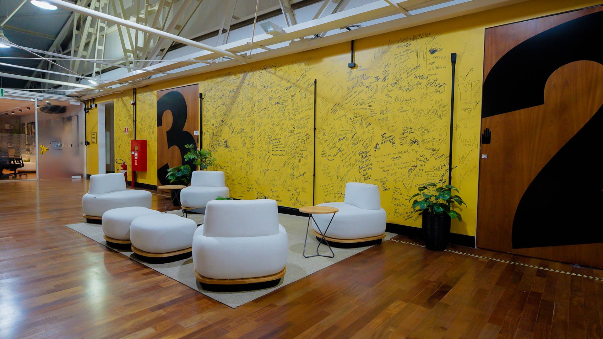Hall com parede de autógrafos no escritório do Podpah
