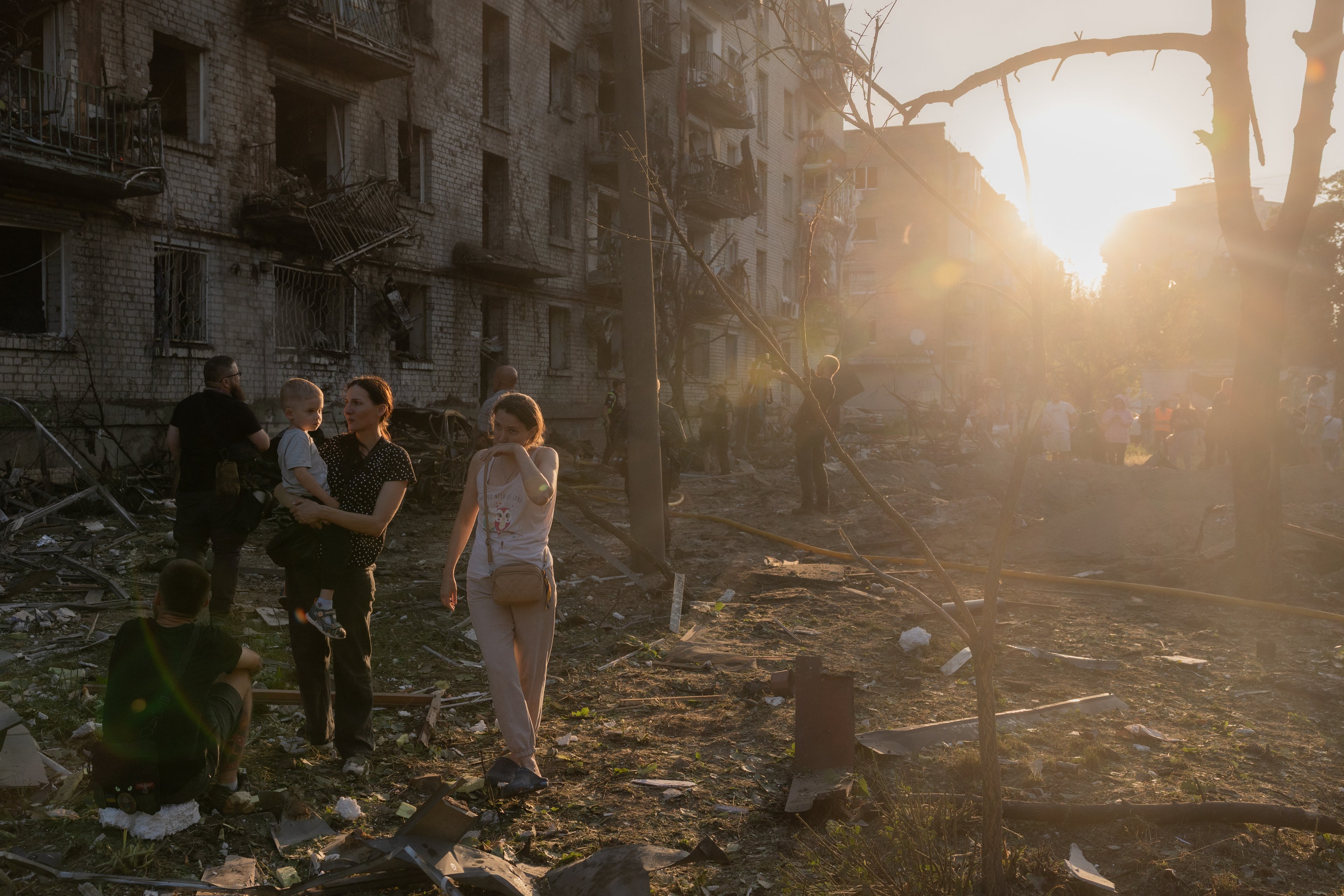 Moradores reúnem-se no local de um prédio residencial danificado após um ataque aéreo russo à capital ucraniana, Kiev, em 2 de julho de 2026, em meio à invasão russa da Ucrânia. Ataques russos com mísseis e drones atingiram Kiev na madrugada de 2 de julho, matando pelo menos oito pessoas e deixando dezenas de feridos, depois que o presidente Volodymyr Zelensky alertou que Moscou estava preparando um 