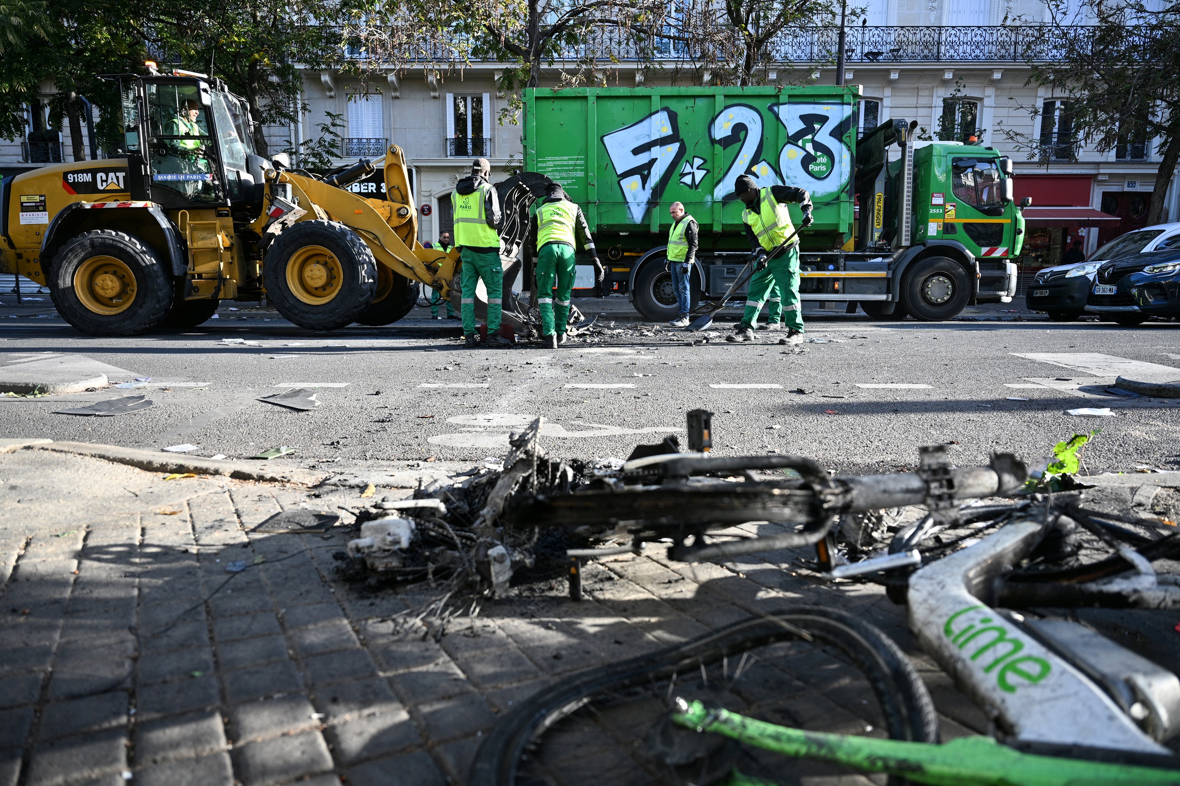 Funcionários municipais limpam as ruas de Paris, removendo estragos e escombros, em 18 de outubro de 2026 — um dia após protestos em todo o país contra o 