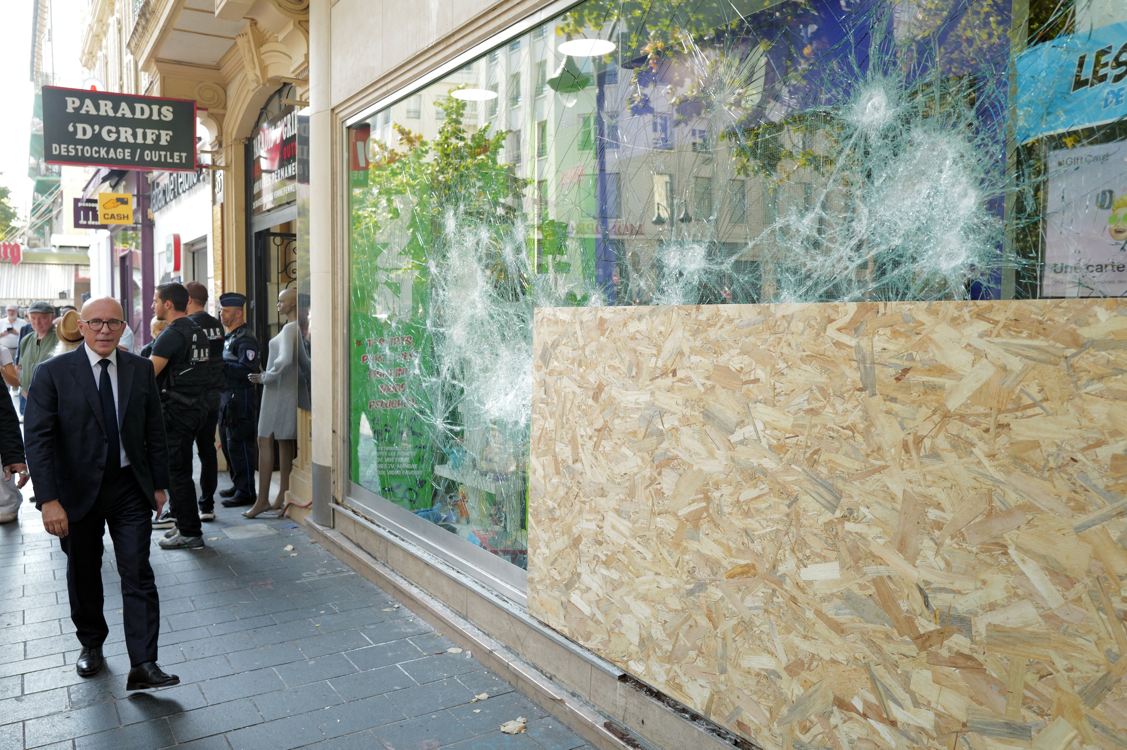 O prefeito de Nice, Eric Ciotti, passa diante de uma loja danificada na avenida Jean-Médecin, em Nice, no sudeste da França, em 18 de outubro de 2026, após protestos em todo o país contra o 